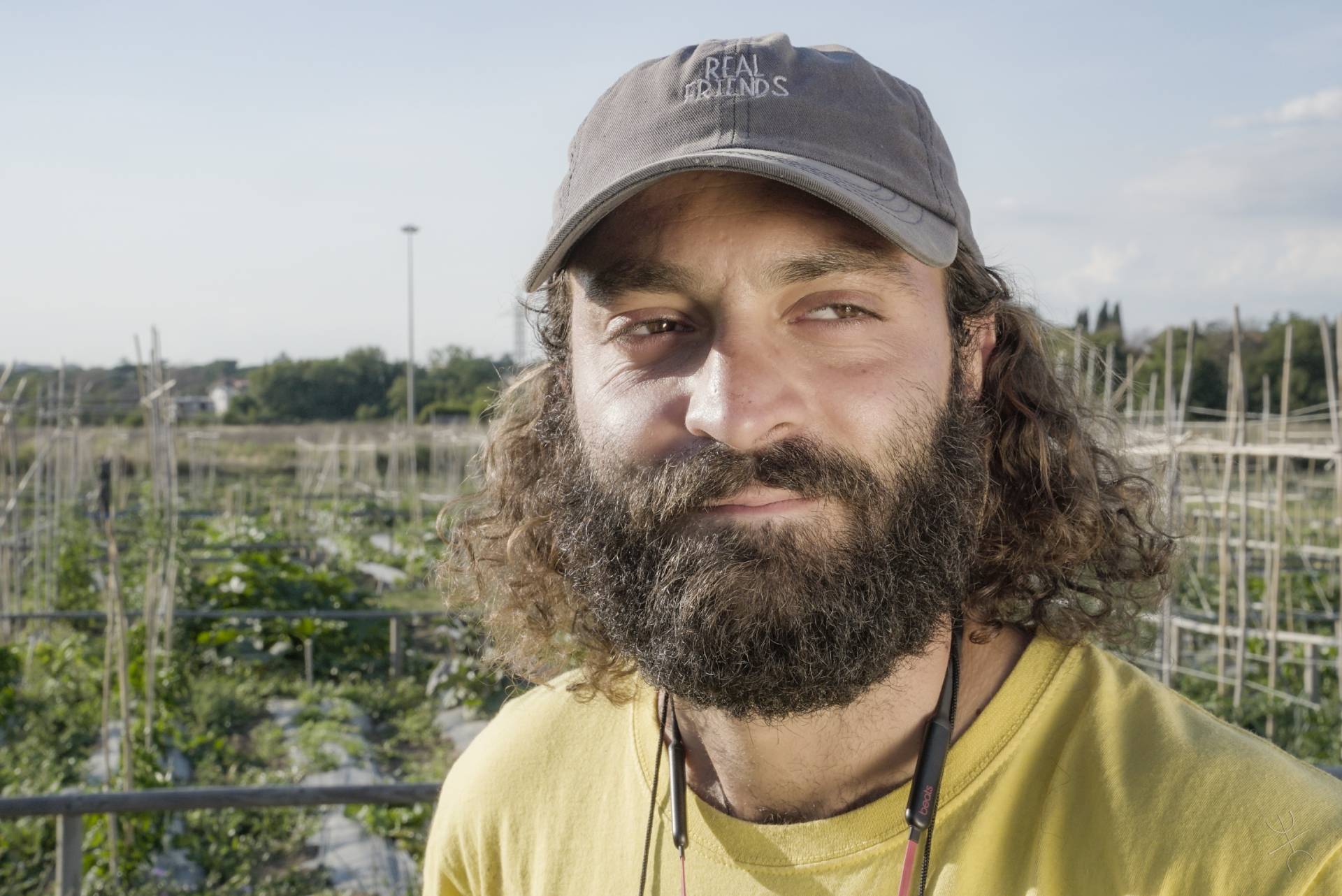 agricoltore con barba e capelli lunghi su un campo da coltivare