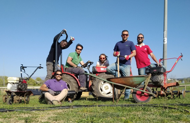 gruppo di lavoro in un orto con strumenti