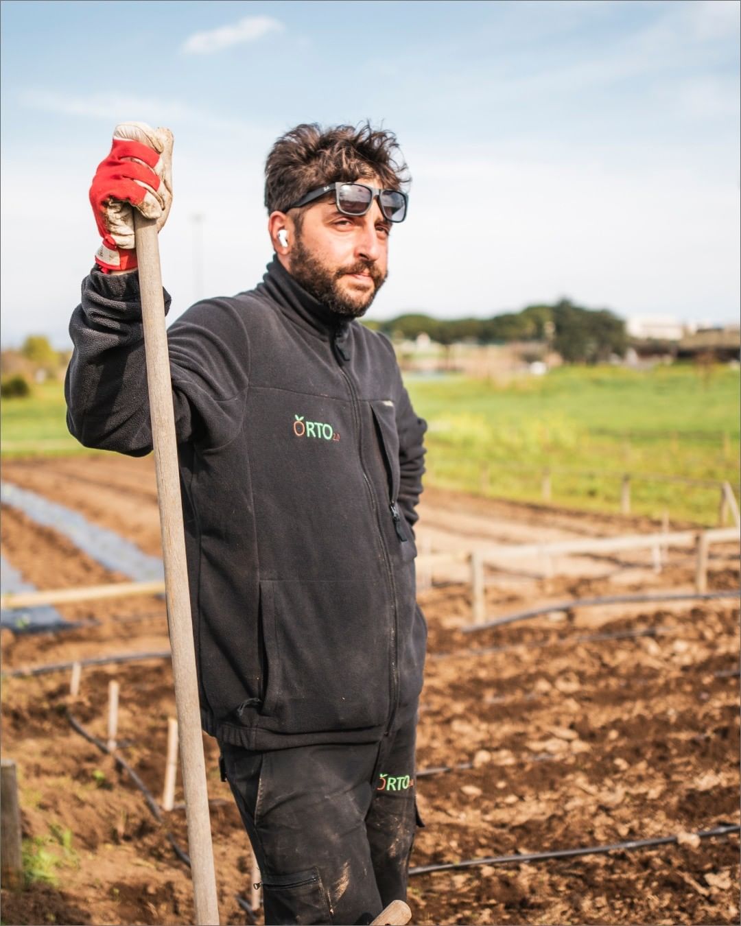 agricoltore in un orto con in mano un badile