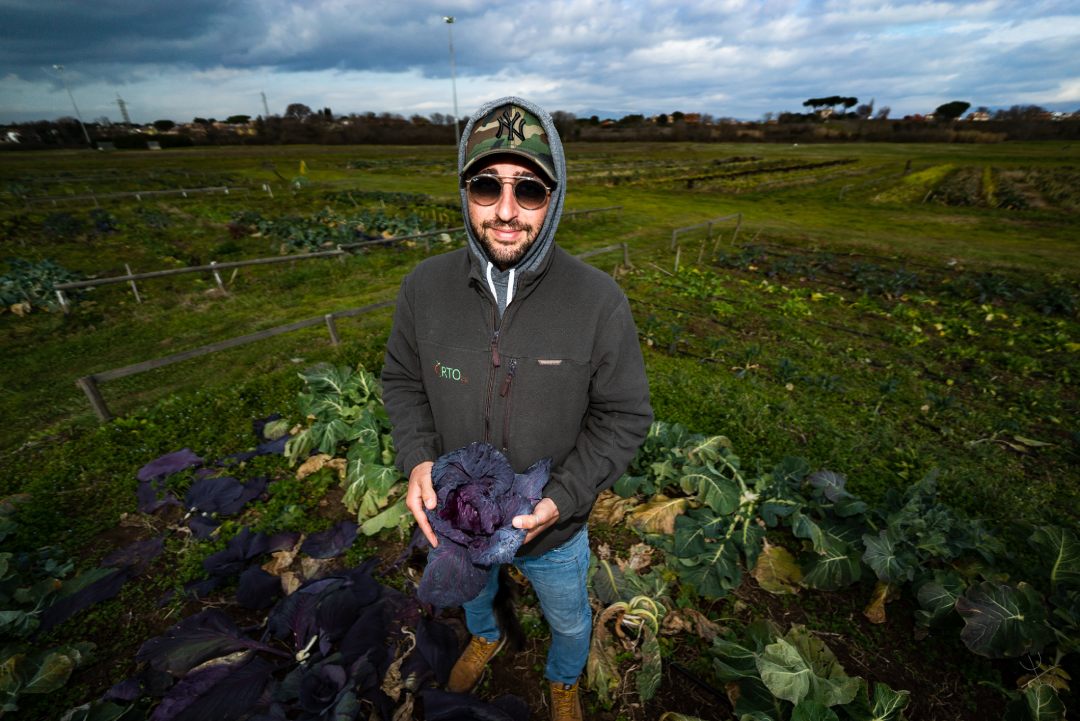 agricoltore con occhiali e cappello con in mano del radicchio